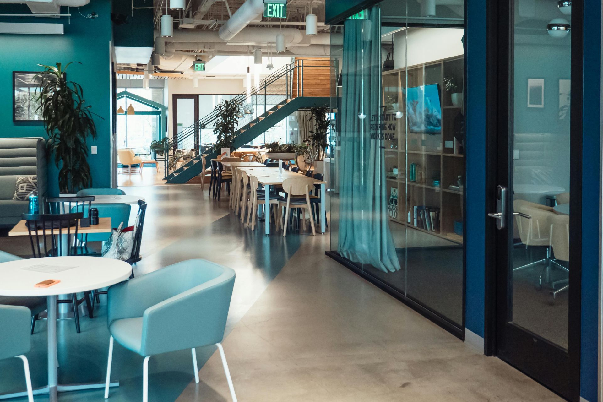 Open and collaborative modern office space with stylish furniture and natural lighting.